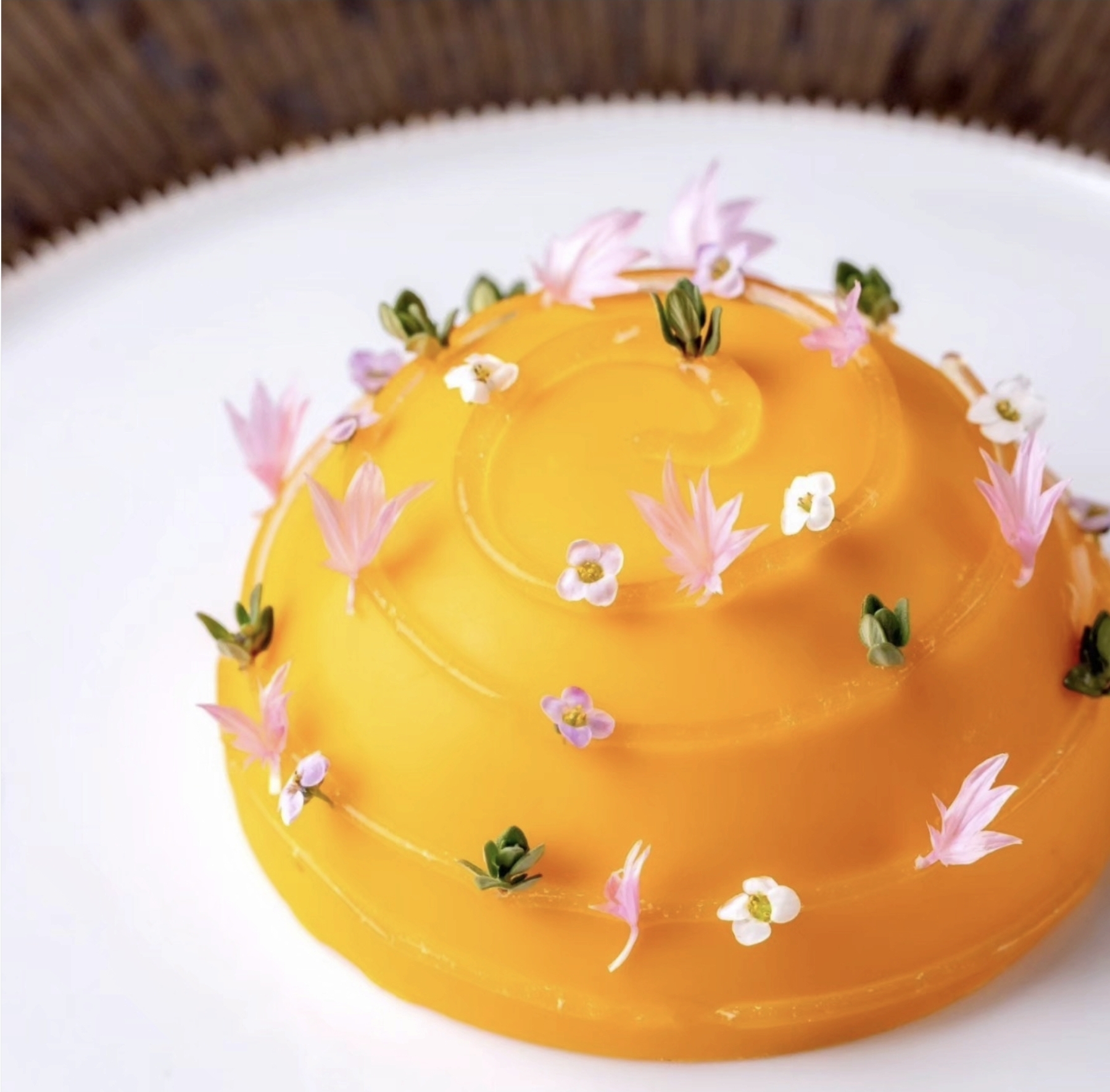 Citrus dome dessert with edible flowers